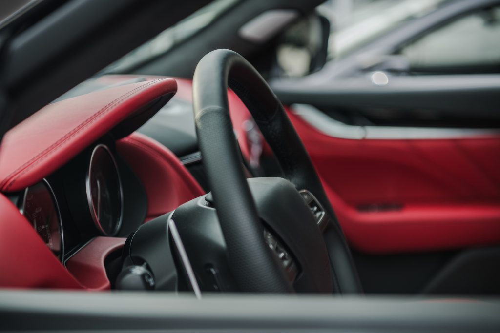 Brand New Elegant Car with Red Leather Finishing Inside a Dealership Showroom. Automotive Industry.