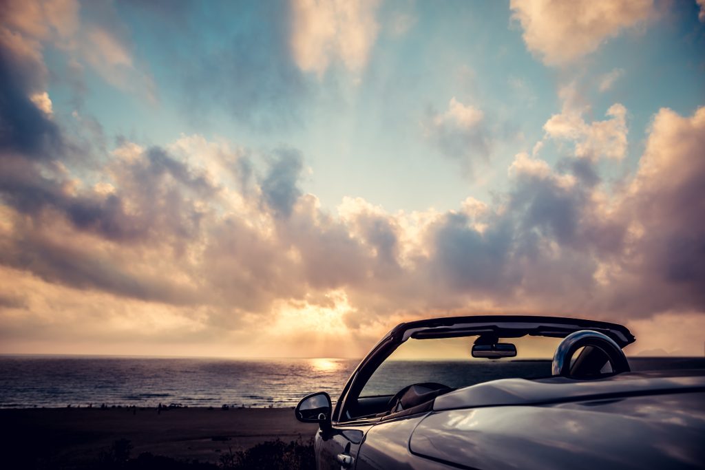 Cabriolet against blue sky background. Summer vacation and travel concept