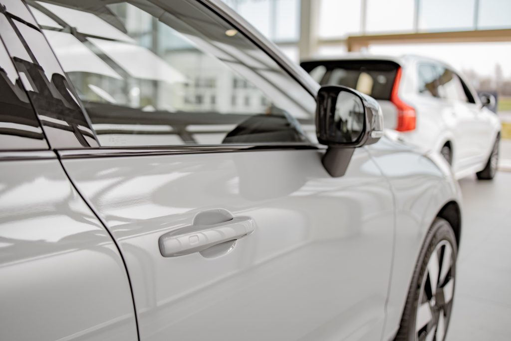 Focus on door of white expensive car with keyless system used for ensuring high level of security against automobile thieves and criminals on high-tech auto model. Low risk concept.