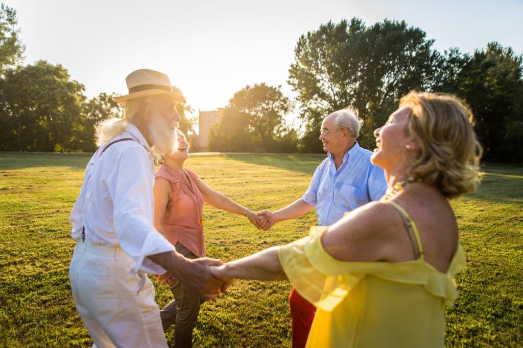 Group of youthful seniors having fun outdoors - Four pensioners bonding outdoors, concepts about lifestyle and elderly