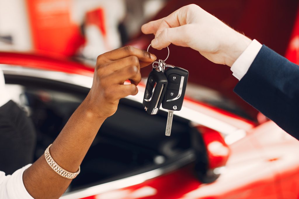 Woman buying the car. Lady in a car salon. Manager with a clients
