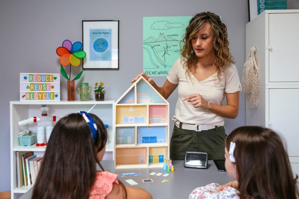 Teacher in an ecology classroom explaining to her students the parts of a sustainable house